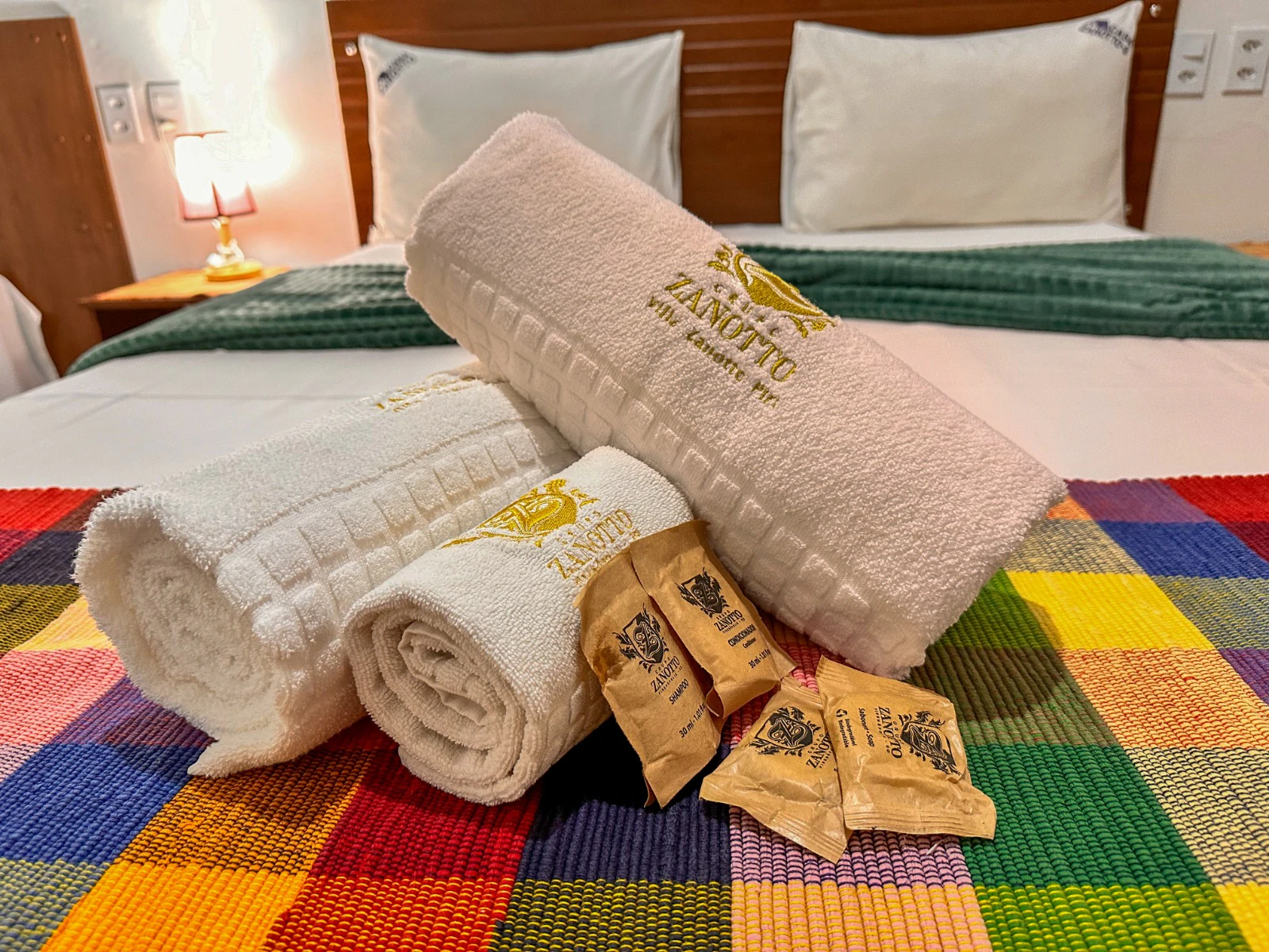 Toalhas e amenities preparados sobre a cama do flat