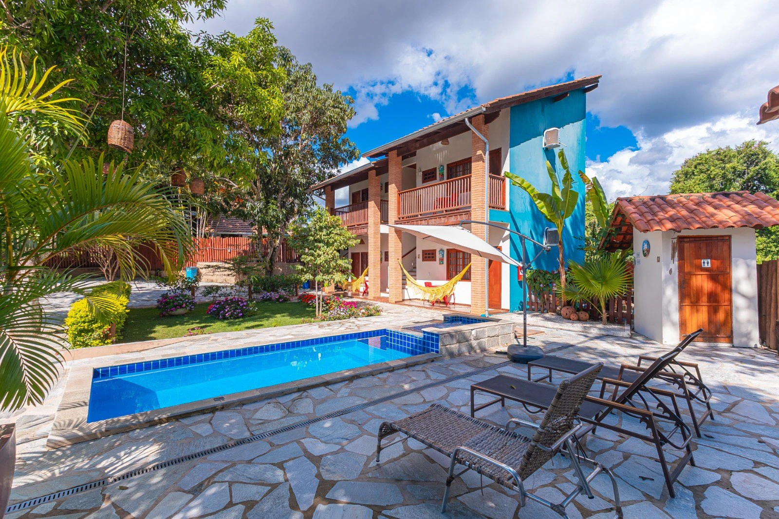 Piscina aquecida com espreguiçadeiras diante dos flats